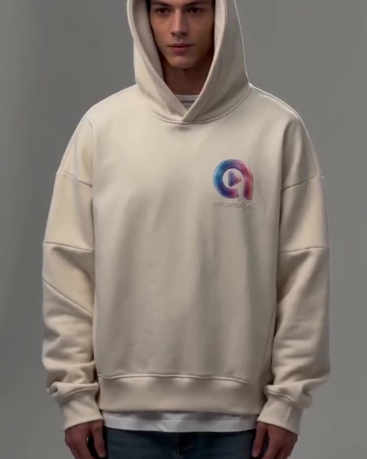 Model in einem cremefarbenen Hoodie vor weißem Hintergrund, daneben Studioblitze und Crew